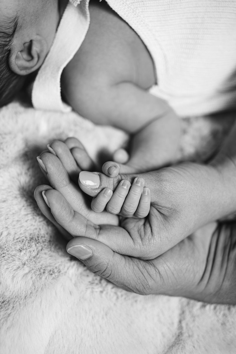 Mains entrelacées d'un parent et d'un nouveau-né